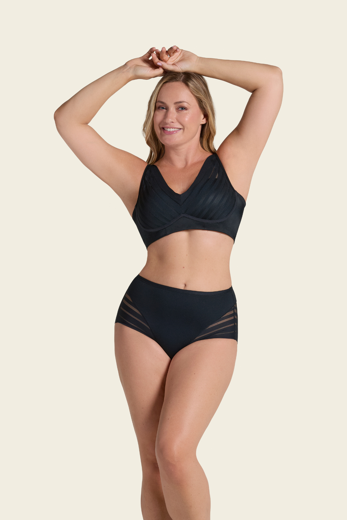 Woman wearing a black bikini set on a beige background